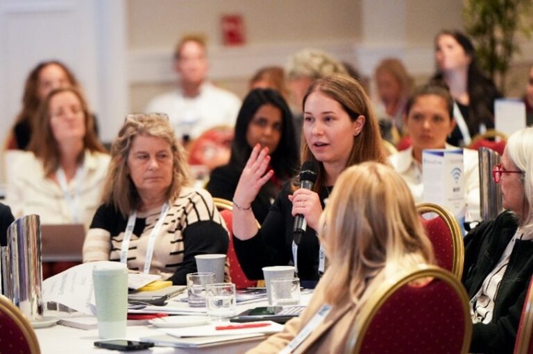 Conference attendee participating in a patient recruitment and clinical research discussion during an interactive healthcare event