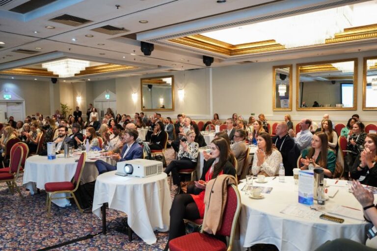 Attendees at a patient recruitment and clinical research conference participating in educational sessions and industry discussions