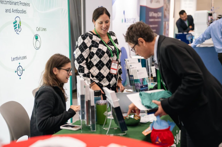 Attendees networking with exhibitors at a life sciences conference focused on clinical research and patient engagement